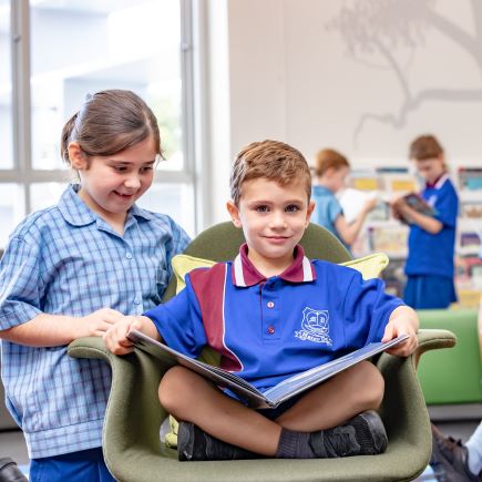 Students engaged in shared reading in a classroom space, highlighting literacy development, collaboration and supportive learning