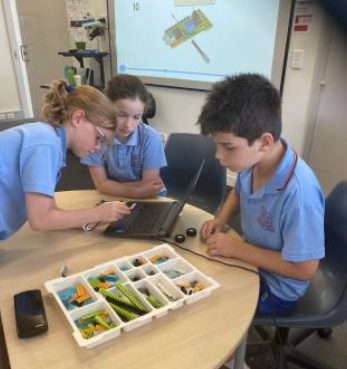 Students working together with LEGO robotics materials and a laptop, highlighting collaborative STEM learning, problem solving and hands‑on classroom inquiry